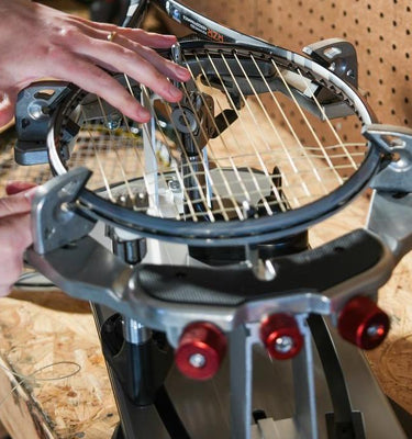 Man using GAMMA Momentum Stringing Machine in his garage